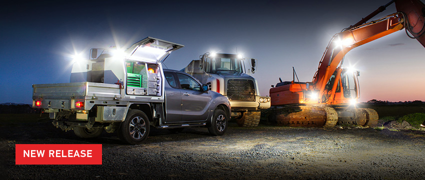 Text New Release over image of Ute, Earthmover, and Excavator with lights at dusk